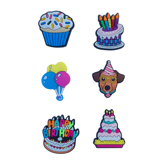 Six colorful birthday-themed shoe charms arranged on a plain white background, including a cupcake, birthday cake with candles, balloons, a dog wearing a party hat and glasses, and two tier birthday cakes with 'Happy Birthday'. Charms for kids.