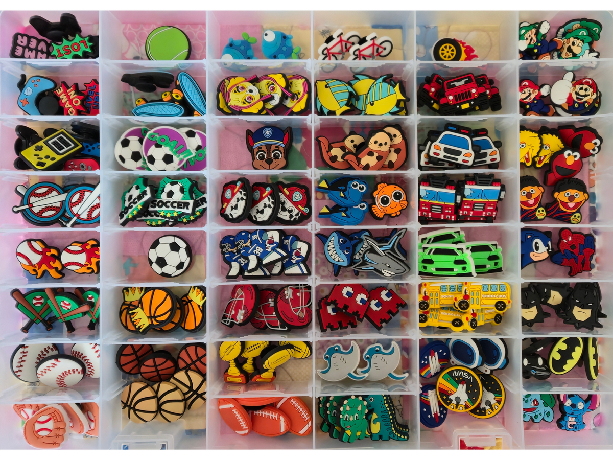 A grid of small compartments filled with colorful embroidered patches featuring sports and pop culture designs, including soccer balls, basketballs, cars, helmets,  superhero, animals, and cartoon characters.